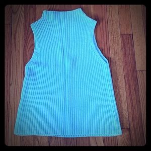 Sleeveless cable knit mock turtleneck sweater.